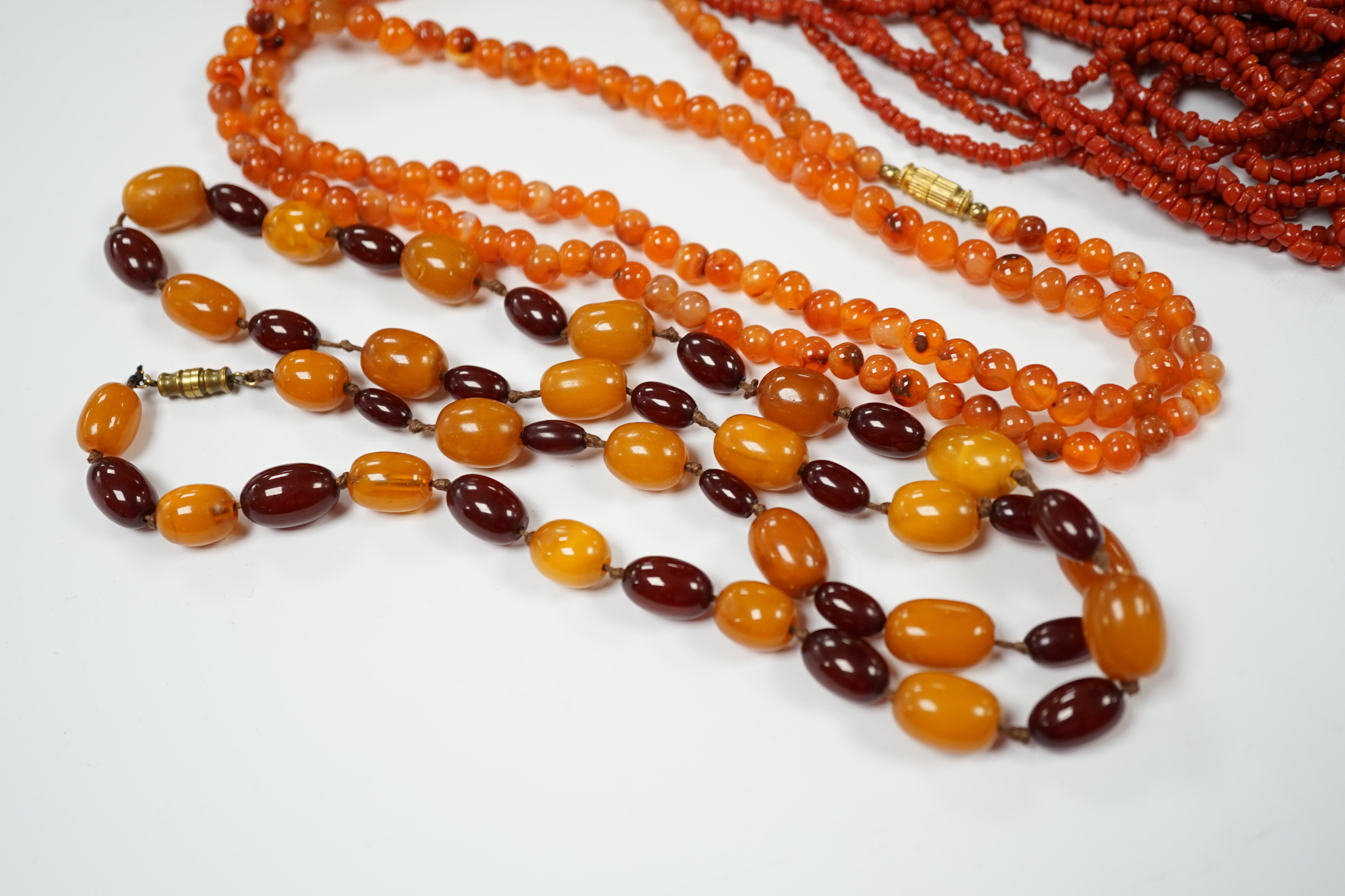 A single strand amber and simulated cherry amber bead necklace, 72cm, gross weight 33 grams, together with two other necklaces including agate bead.